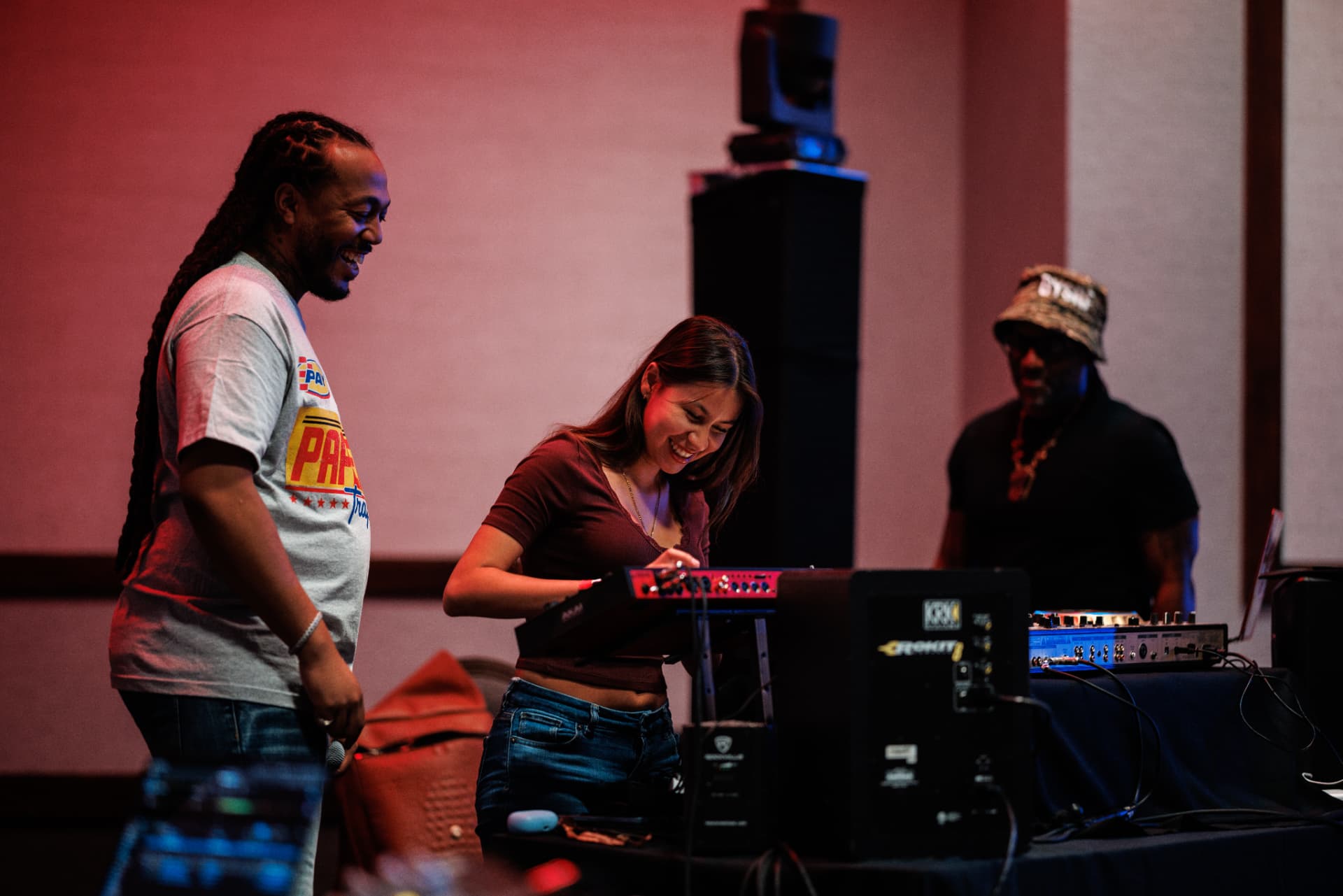 A student learning beat making on a music controller with a facilitator beside her